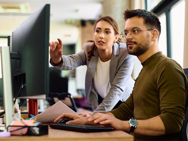 un uomo e una donna davanti al PC